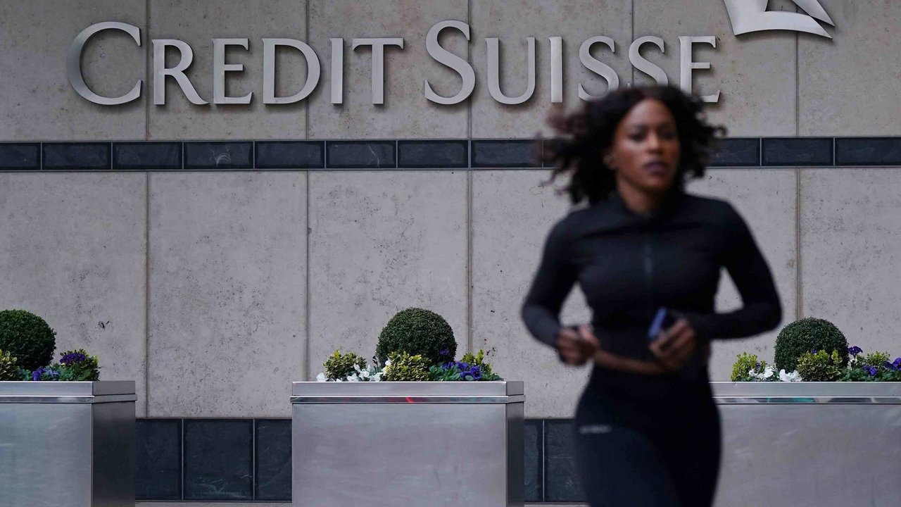 Unha muller corre diante da sede do banco Credit Suisse en Londres (Foto: Yui Mok / PA Wire / DPA).