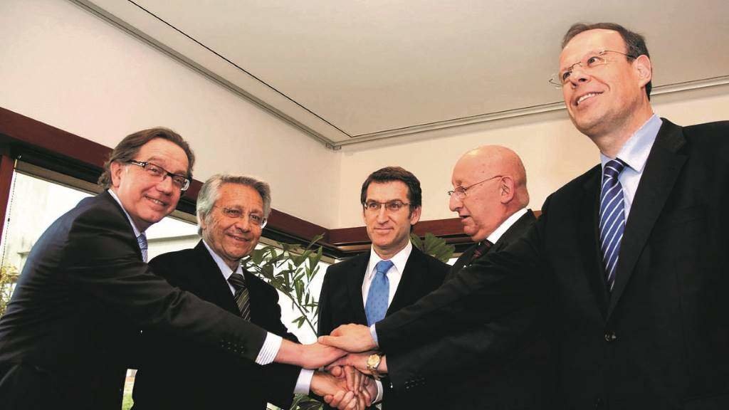 No centro, Alberto Núñez Feixoo, quen liderou o proceso de fusión das caixas galegas, cos directivos de Caixa Galicia e Caixanova. (Foto: Europa Press)