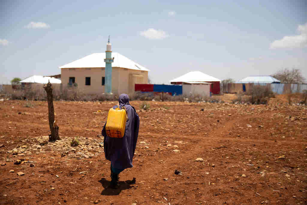 Unha crianza camiña cara á súa casa en Somalia despois de conseguir auga nun centro de distribución organizado para enfrontar a seca. (Foto: Mustafa Olgun)