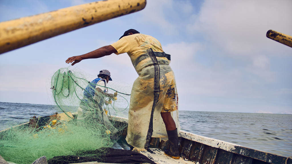 Mariñeiros peruanos preparan as redes de pesca nun bote no medio do océano Pacífico. (Foto: Alex Fernández)
