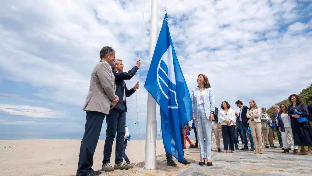 Alfonso Rueda izando a bandeira azul dunha praia en Arteixo. (Foto: David Cabez&oacute;n)