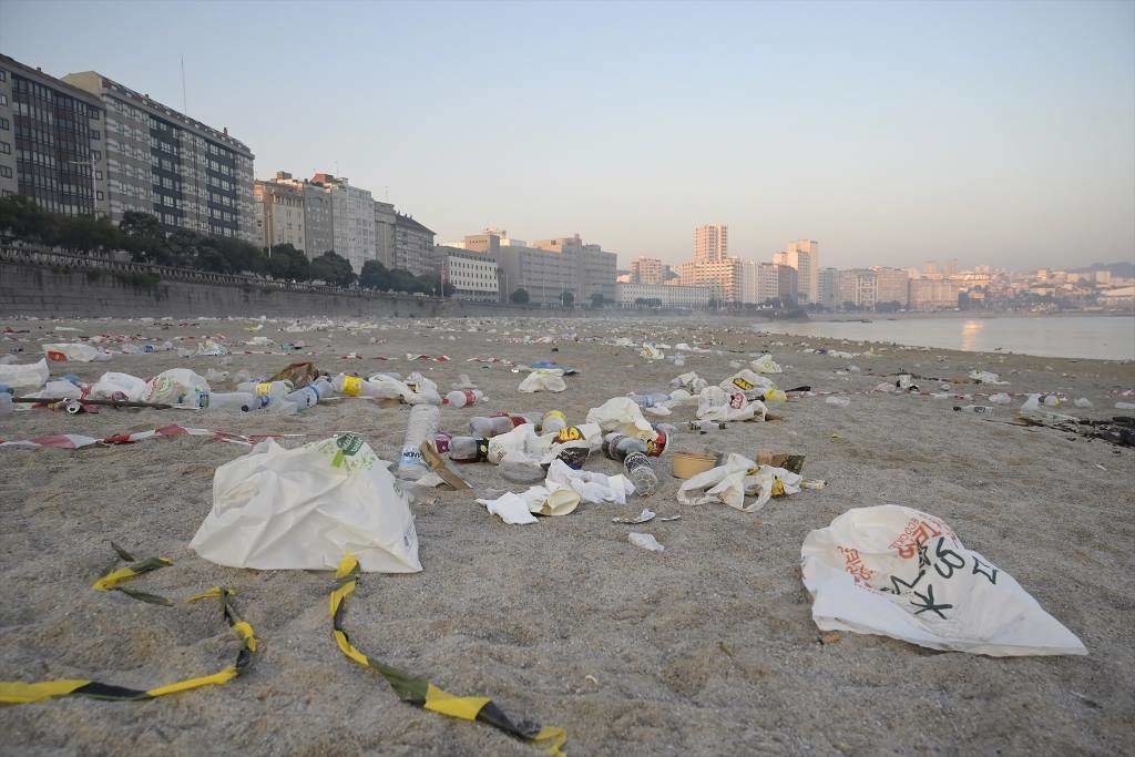Restos de lixo despois da celebración do San Xoán, na praia do Orzán, na Coruña.
