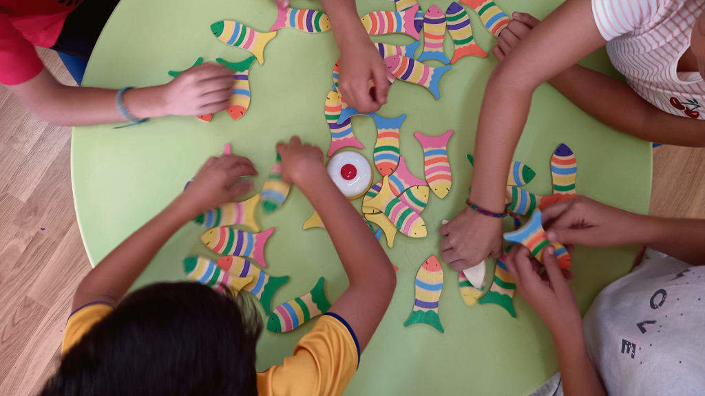 Un grupo de crianzas comparten un xogo de mesa de Brazolinda. (Foto: Nós Diario)