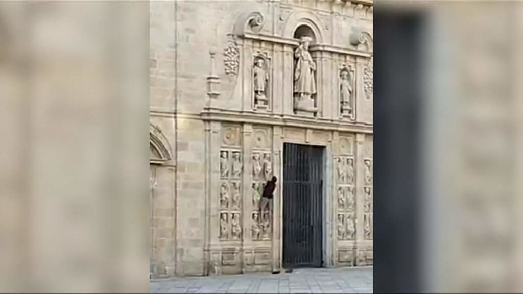 Home escalando a fachada da Porta Santa da Catedral de Santiago de Compostela, este domingo 2 de xullo. (Foto: Apatrigal)