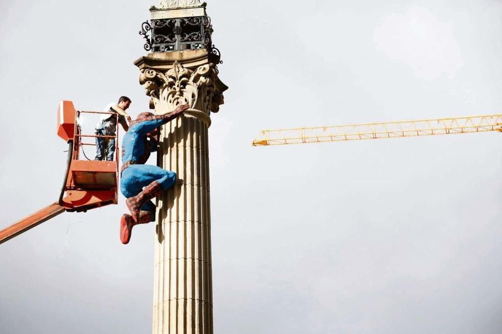 Un operario coloca unha figura de Spiderman no obelisco da Coruña. (Foto: Vanessa Rábade)