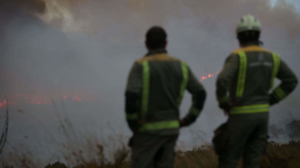 Varios axentes de emerxencias observan o incendio forestal de Palas de Rei. (Foto: Carlos Castro/Europa Press).