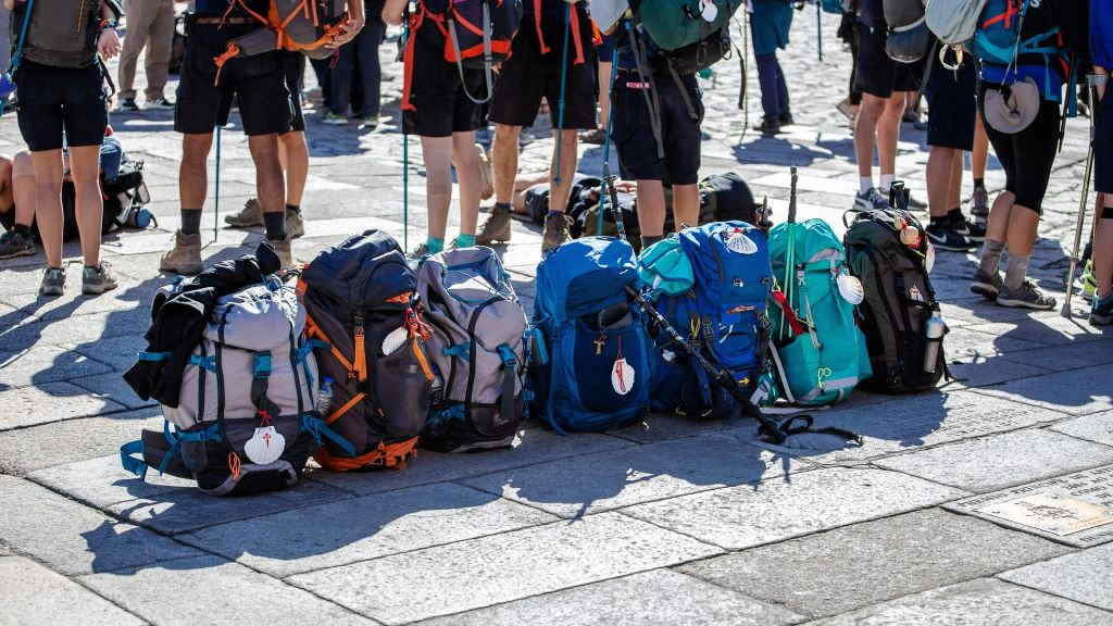 Un grupo de peregrinos deixa as súas mochilas no chan tras a súa chegada á praza do Obradoiro. (Foto: Nós Diario).