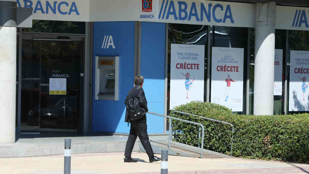 Un home pasa diante dunha oficina de Abanca. (Marta Fernández / Europa Press).