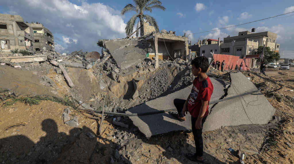 Unha crianza palestina olla os edificios derrubados polos bombardepos israelitas en Gaza (Foto: Abed Rahim Khatib / dpa).
