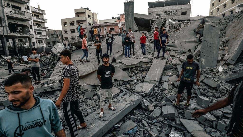 Palestinos inspeccionan un edificio destruído polos ataques aéreos israelís na zona fronteiriza de Gaza con Rafah (Exipto). [Foto: Abed Rahim Khatib / DPA]