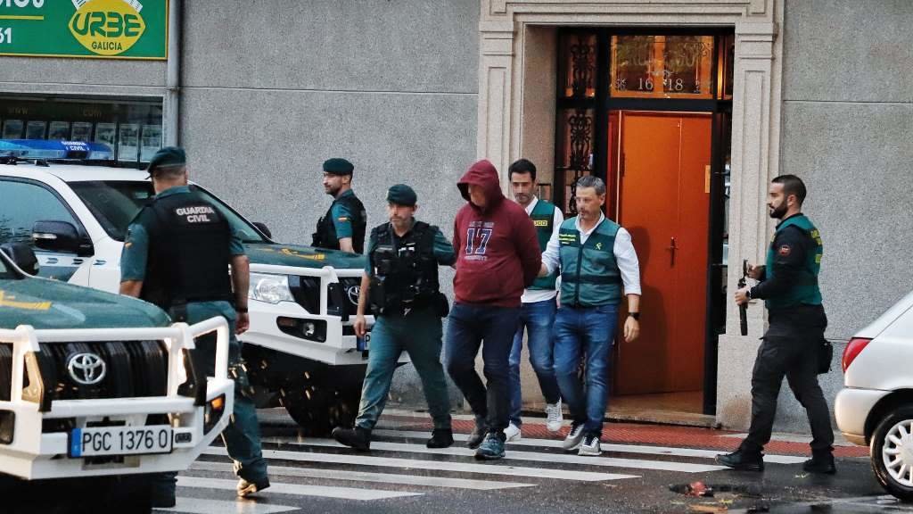 O detido saíndo esposado do seu domicilio en Narón. (Foto: Europa Press)