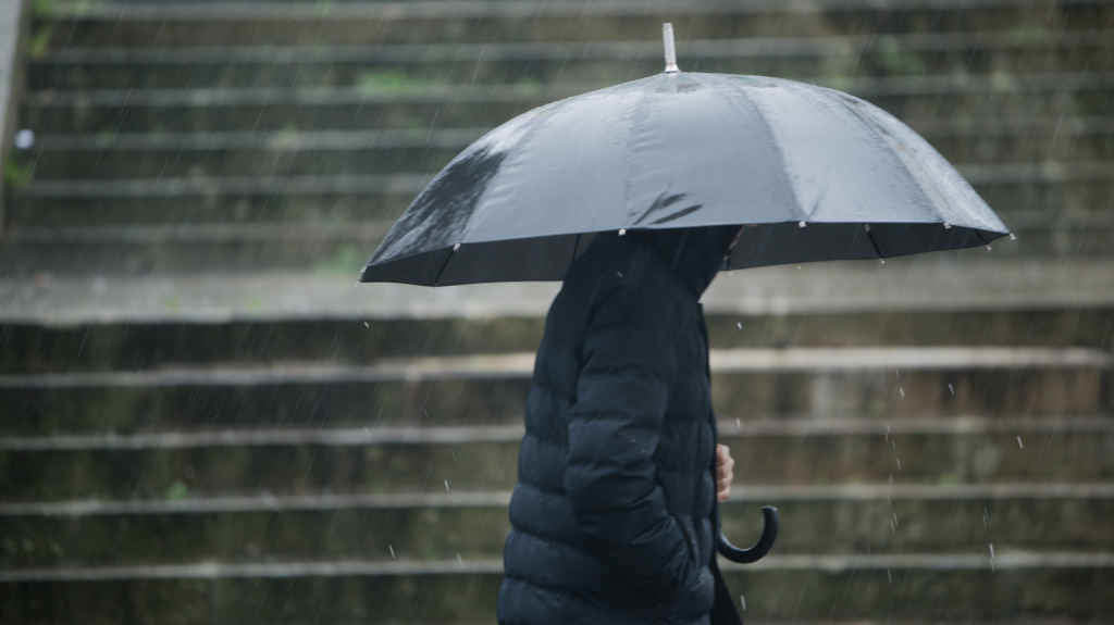 Unha persoa protéxese da chuvia en Santiago de Compostela nunha imaxe de arquivo (Foto: Gustavo de la Paz / Europa Press).