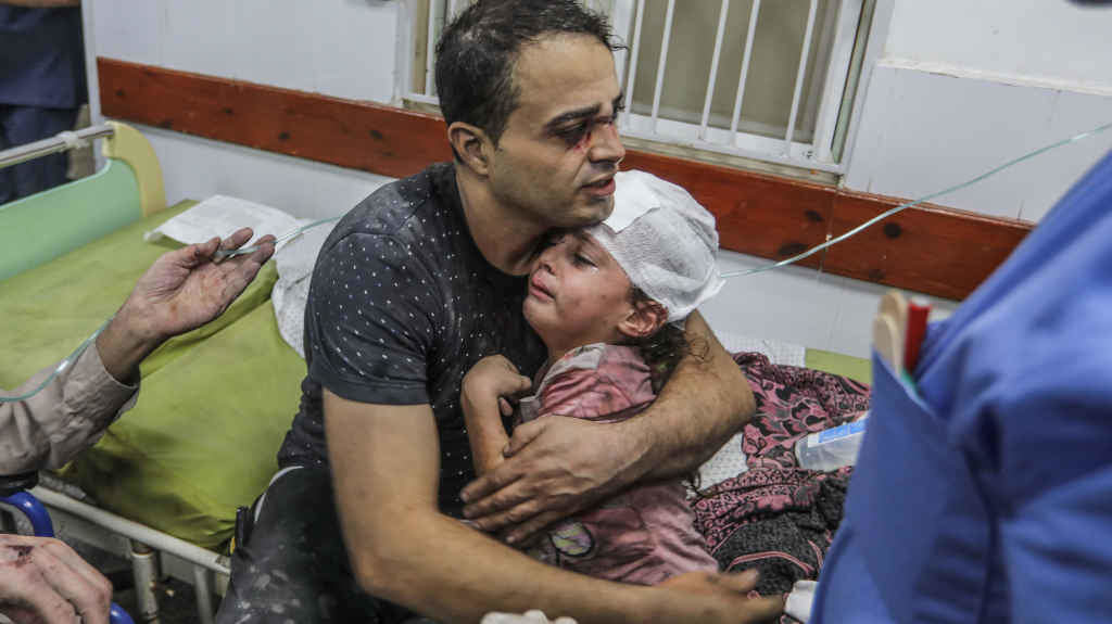 Un pai abraza a súa filla ferida tras un ataque israelí (Foto: Abed Rahim Khatib / dpa).