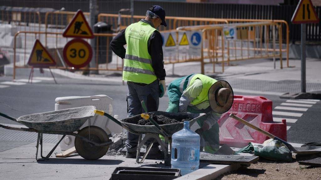 Dous obreiros traballando nunha obra de pavimentación. (Foto: Fernando Sánchez / Europa Press)