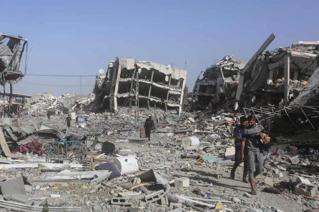 Palestinos entre os cascallos da localidade de al Zahra, no centro da Faixa de Gaza. (Foto: Mohammed Talatene / DPA)