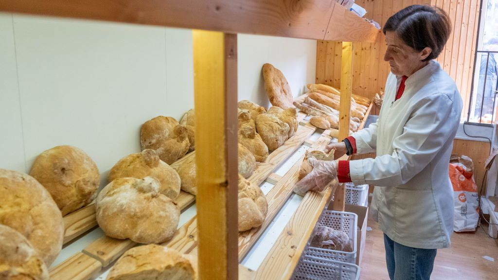 Unha muller despacha pan nun forno de leña en Compostela. (Foto: Arxina).
