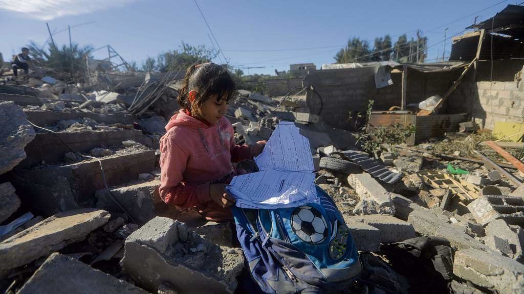 Ruaa Thaer Barhoum, de 9 anos, busca na mochila escolar entre os cascallos da súa casa destruída por Israel en Rafah a pasada sexta feira. (Foto: Mohammed Talatene)