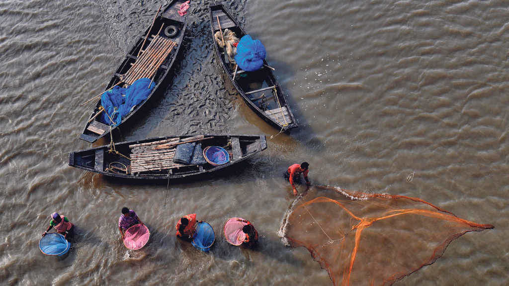 Unha familia de pescadores utiliza redes de cores no río Matla, en Bengala Occidental (India) (Foto: Avishek Das).