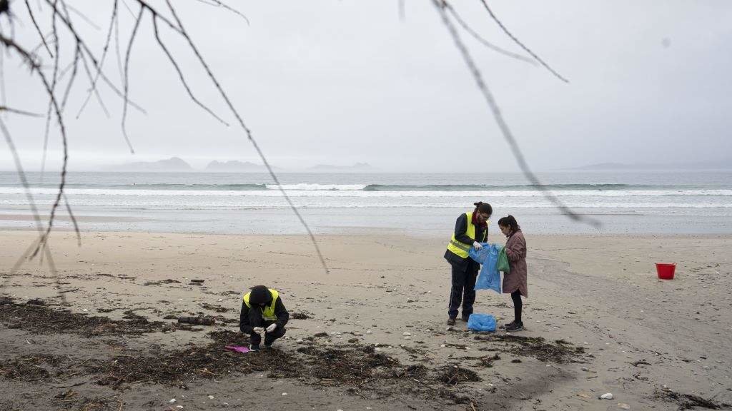 Taferas de limpeza de pellets na praia de Patos, en Nigrán (comarca de Vigo). (Foto: Adrián Irago / Europa Press)