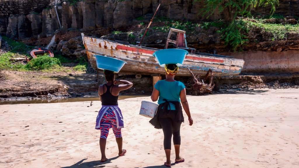 Dúas mulleres transportan peixe na praia de Tarrafal, na illa de Santiago, en Cabo Verde. (Foto: S. Aznar)