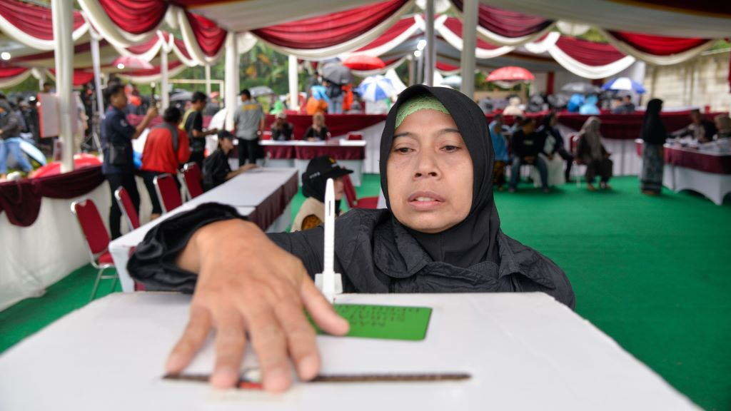 Unha muller emite seu voto no colexio electoral número 35 en Bogor, Indonesia, o pasado 14 de febreiro. (Foto: Xu Qin / Xinhua News).