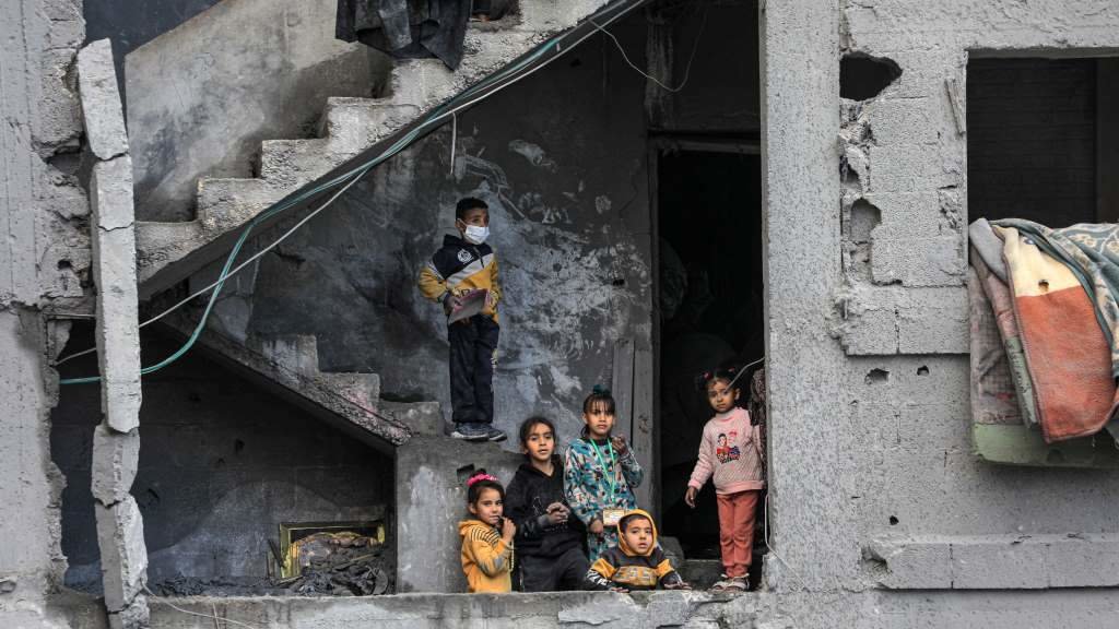 Seis crianzas sobre os cascallos dun edificio derrubado polo fogo israelí na cidade de Rafah, ao sur de Gaza. (Foto: Rizek Abdeljawad / Xinhua News)