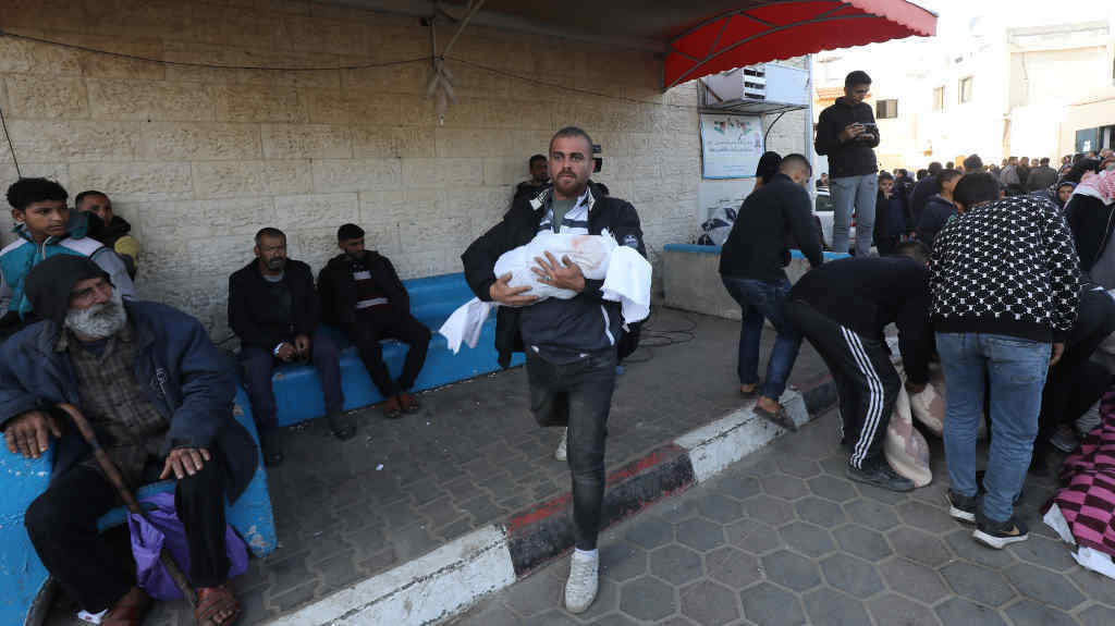 Un familiar recolle o cadáver dunha crianza a cuarta feira no hospital al Aqsa da Faixa de Gaza. (Foto: Ali Hamad / Zuma Press)