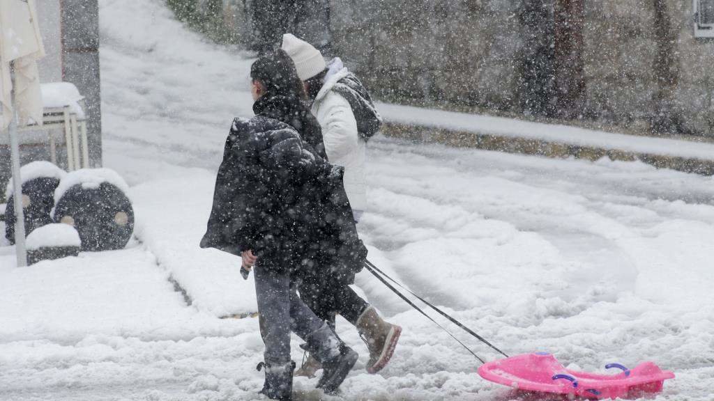Dúas persoas camiñan pola neve en Castroverde (comarca de Lugo). (Foto: Carlos Castro / Europa Press)
