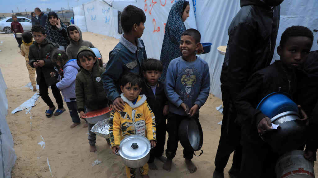 Crianzas nunha fileira para conseguir comida en Rafah, no sur da Faixa de Gaza, a segunda feira. (Foto: Rizek Abdeljawad / Xinhua News)