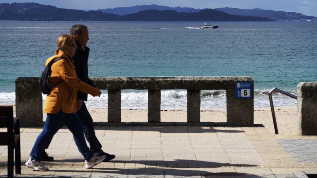 Dúas persoas camiñan pola beira do mar en Sanxenxo, no Salnés (Foto: Álvaro Ballesteros / Europa Press).