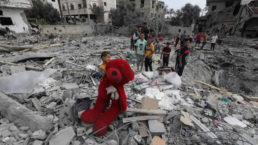 Un neno sost&eacute;n un oso de peluche sobre os cascallos dun edificio derru&iacute;do en Al-Zawayda, no centro da Faixa de Gaza. (Foto: Omar Naaman / DPA v&iacute;a Europa Press)