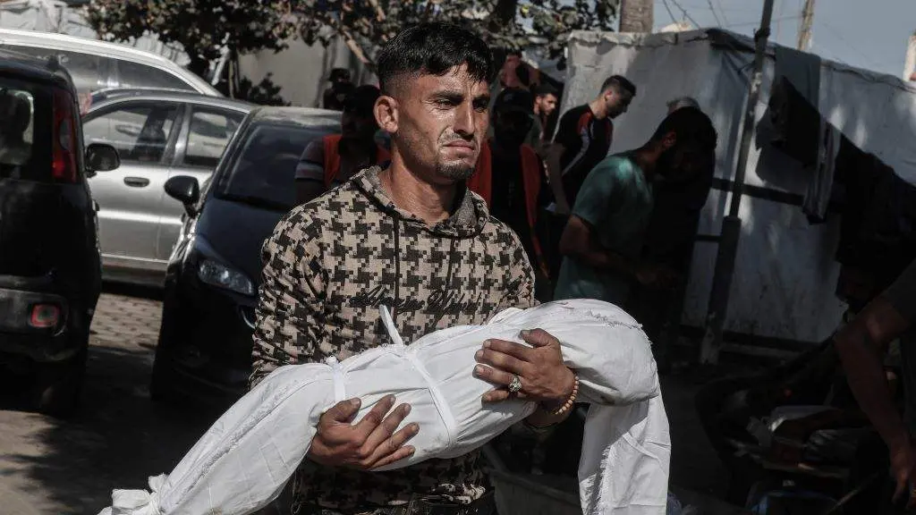 Un home sostendo o cad&aacute;ver dunha crianza nos arredores do hospital de Al-Aqsa. (Foto: Omar Ashtawy / Zuma Press / ContactoPhoto v&iacute;a Europa Press)
