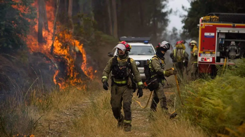 Axentes do equipo de Bombeiros da Galiza traballando na extinci&oacute;n dun incendio en Crecente (A Parandanta). (Foto: Adri&aacute;n Irago / Europa Press)