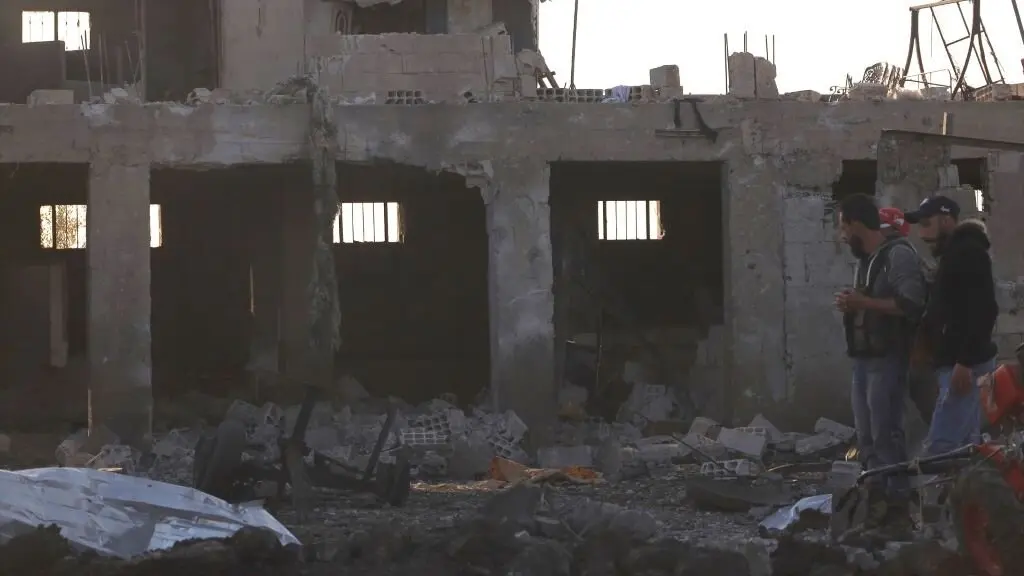 Persoas diante dun edificio destru&iacute;do nun suposto ataque con drons israel&iacute;s en Sweida, no sur de Siria, o 2 de maio de 2025. (Foto: Europa Press / Contacto / string)