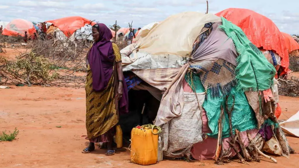 Unha muller desprazada pola seca, en Somalia, xunto a unha estrutura improvisada do Programa Mundial de Alimentos. (Foto: Hassan Ali Elmi / AFP / AI)