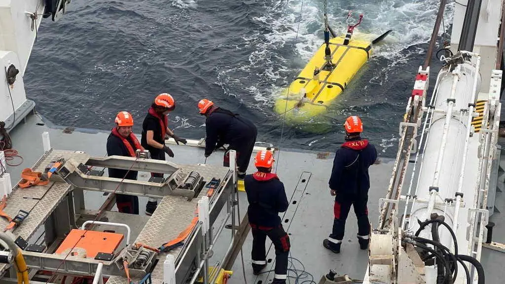 O equipo de investigaci&oacute;n a bordo de L'Atalante manexa o robot submarino UlyX. (Foto: Javier Escart&iacute;n)