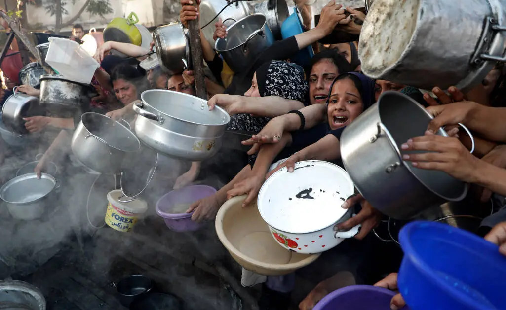EuropaPress_6867383_gaza_city_july_21_2025____palestinians_wait_to_receive_food_in_the_al_rimal
