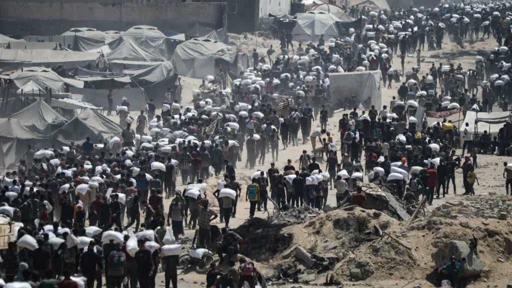 Palestinos cargan sacos de axuda na Cidade de Gaza, no norte do enclave, o 27 de xullo de 2025. (Foto: Omar Ashtawy / APA Images v&iacute;a ZUMA / DPA v&iacute;a Europa Press)