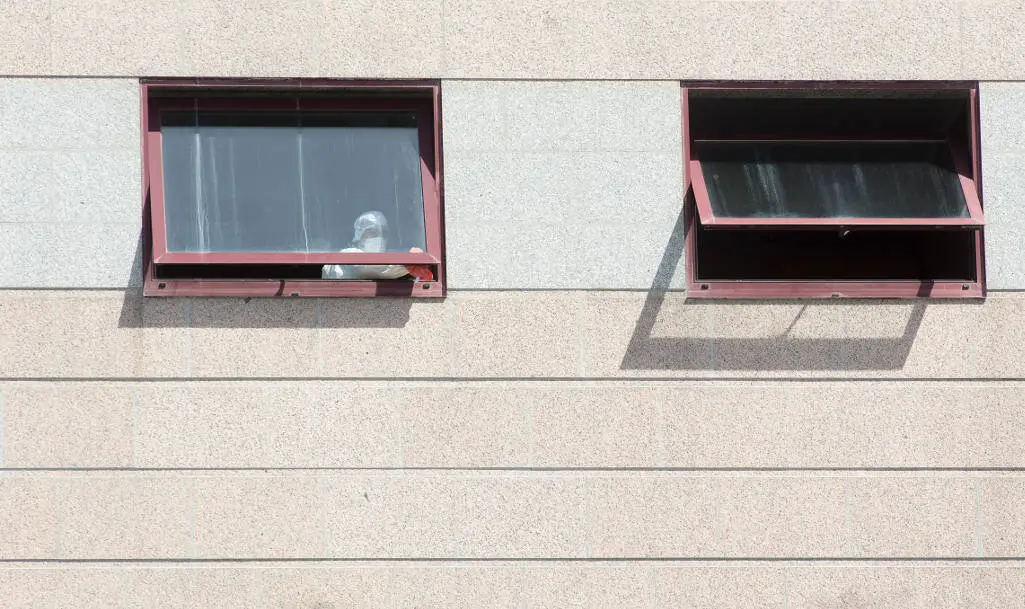 Outeiro de Rei, Lugo. Mas de 100 positivos por Covid19 en la Residencia de Maiores de la cadena DomusVi en Outeiro de Rei. Casi la totalidad de los usuarios se encuentran infectados. En la imagen, una trabajadora del centro limpia las ventanas ataviada con equipo de seguridad en la tarde del martes 8 de septiembre