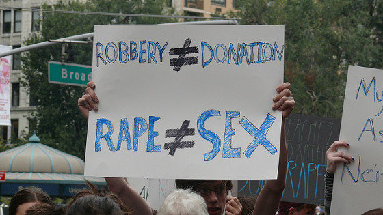 [Imaxe: Charlotte Cooper] Cartaz que indica que un atraco non é unha doazón e que unha agresión sexual non é sexo.