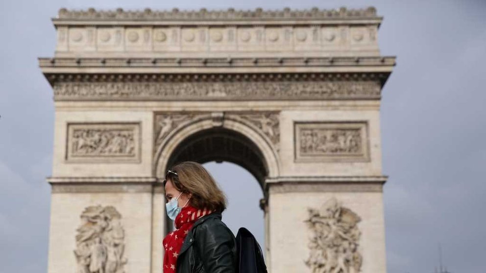Unha muller con máscara pasea polas rúas de París (Foto: Europa Press).