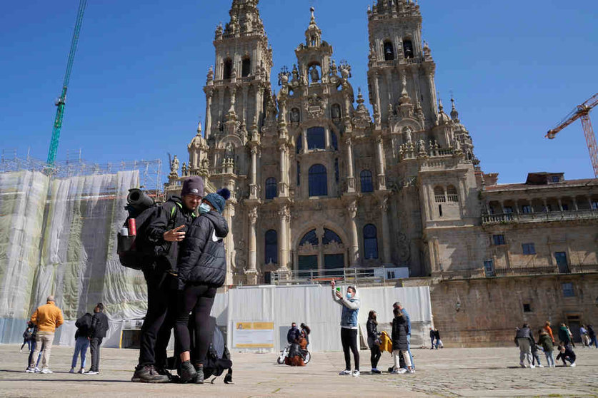 Dous turistas tiran unha foto na praza do Obradoiro en 2021, durante o Xacobeo, que multiplica o turismo cara a Compostela. (Foto: Álvaro Ballesteros / Europa Press)