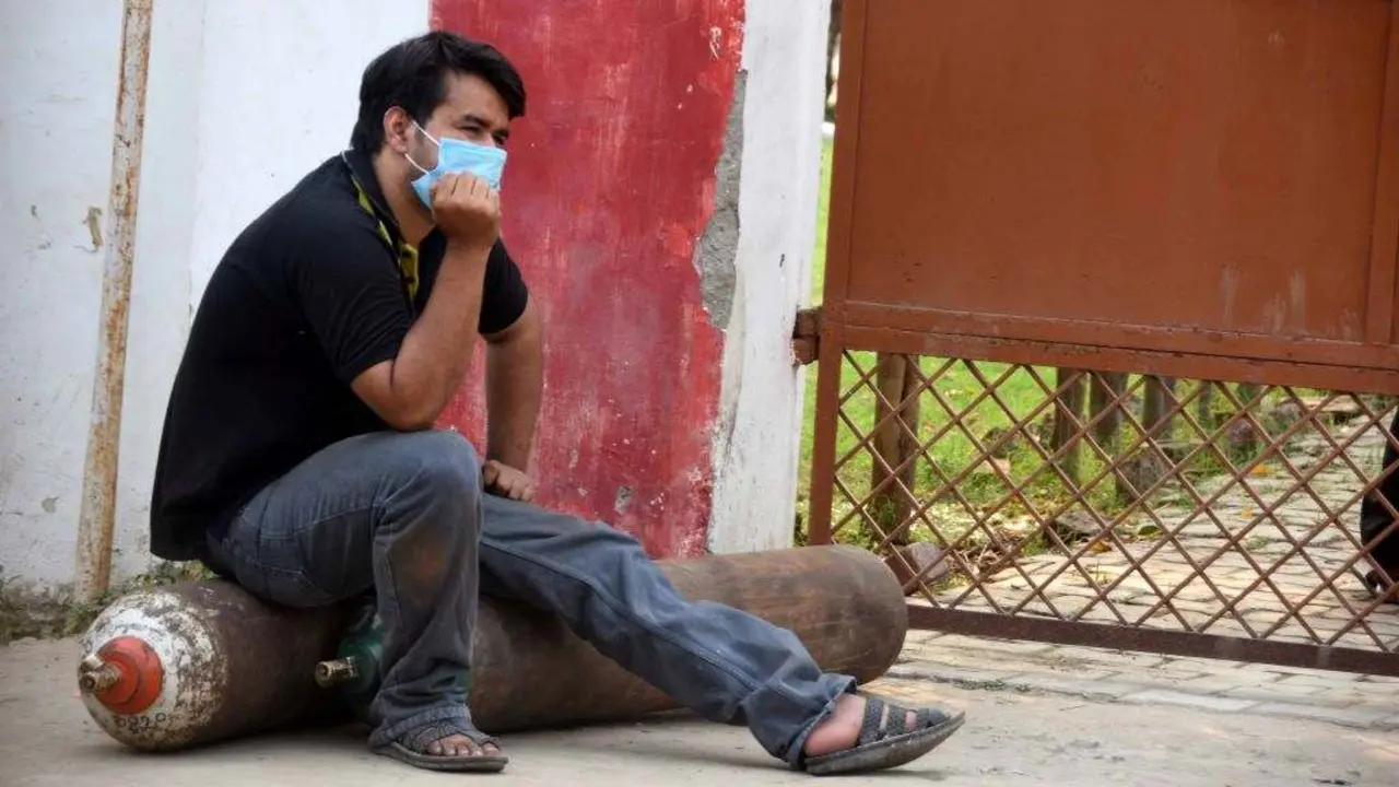 Un home sobre unhas bombonas de os&iacute;xeno na India. (Foto: Prabhat Kumar Verma / ZUMA Wire / DPA)