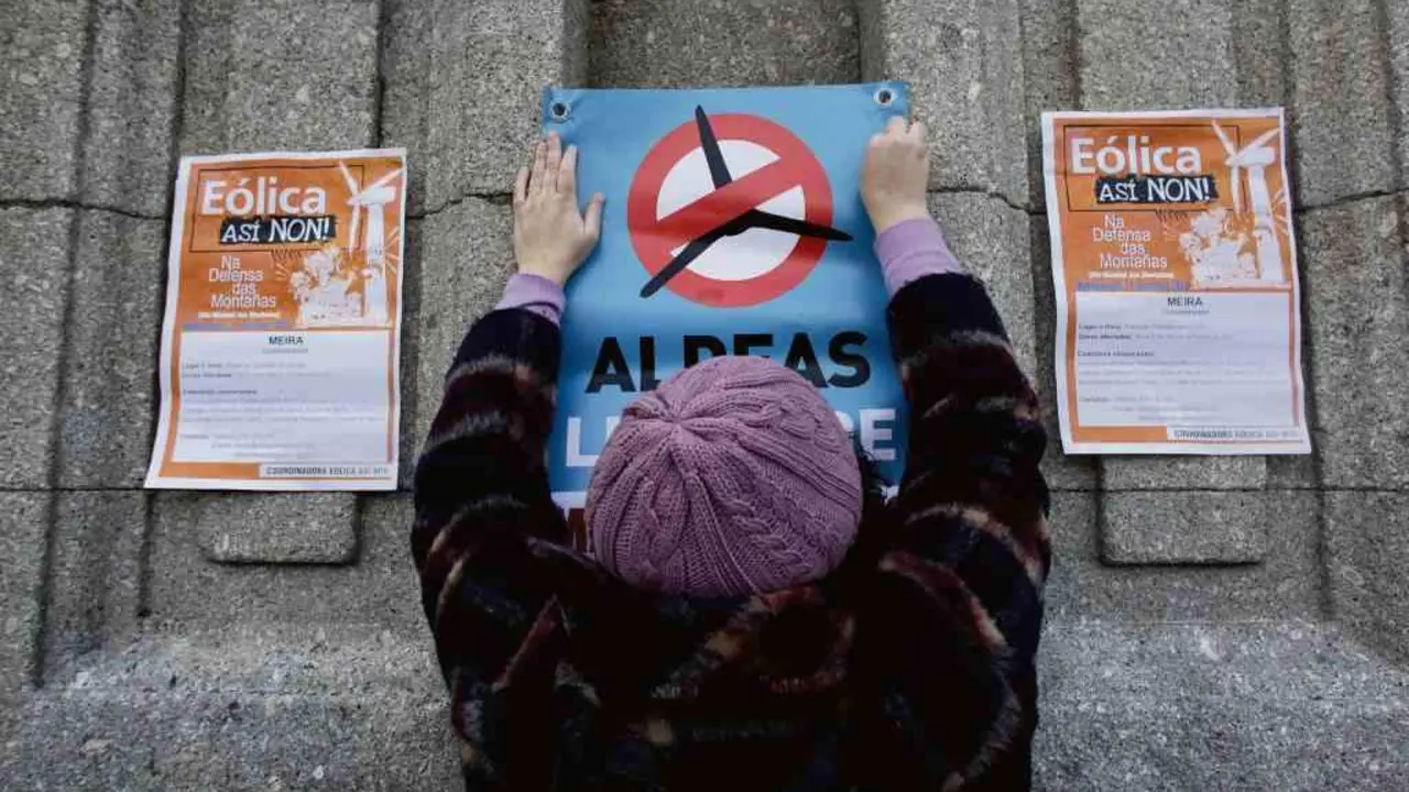 Unha muller pega un cartaz contra a invasi&oacute;n e&oacute;lica en Meira, o 11 de decembro. (Foto: Europa Press)