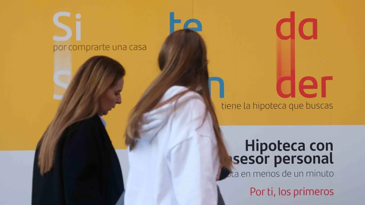 D&uacute;as mulleres cami&ntilde;an por diante dunha sucursal bancaria. (Foto: Arxina)