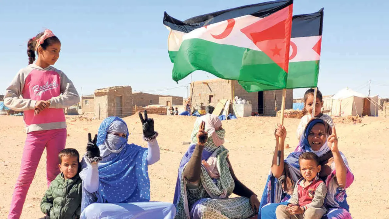 Tres saharau&iacute;s fan o s&iacute;mbolo da vitoria nun campo de refuxiadas e refuxiados. (Foto: Cedida)