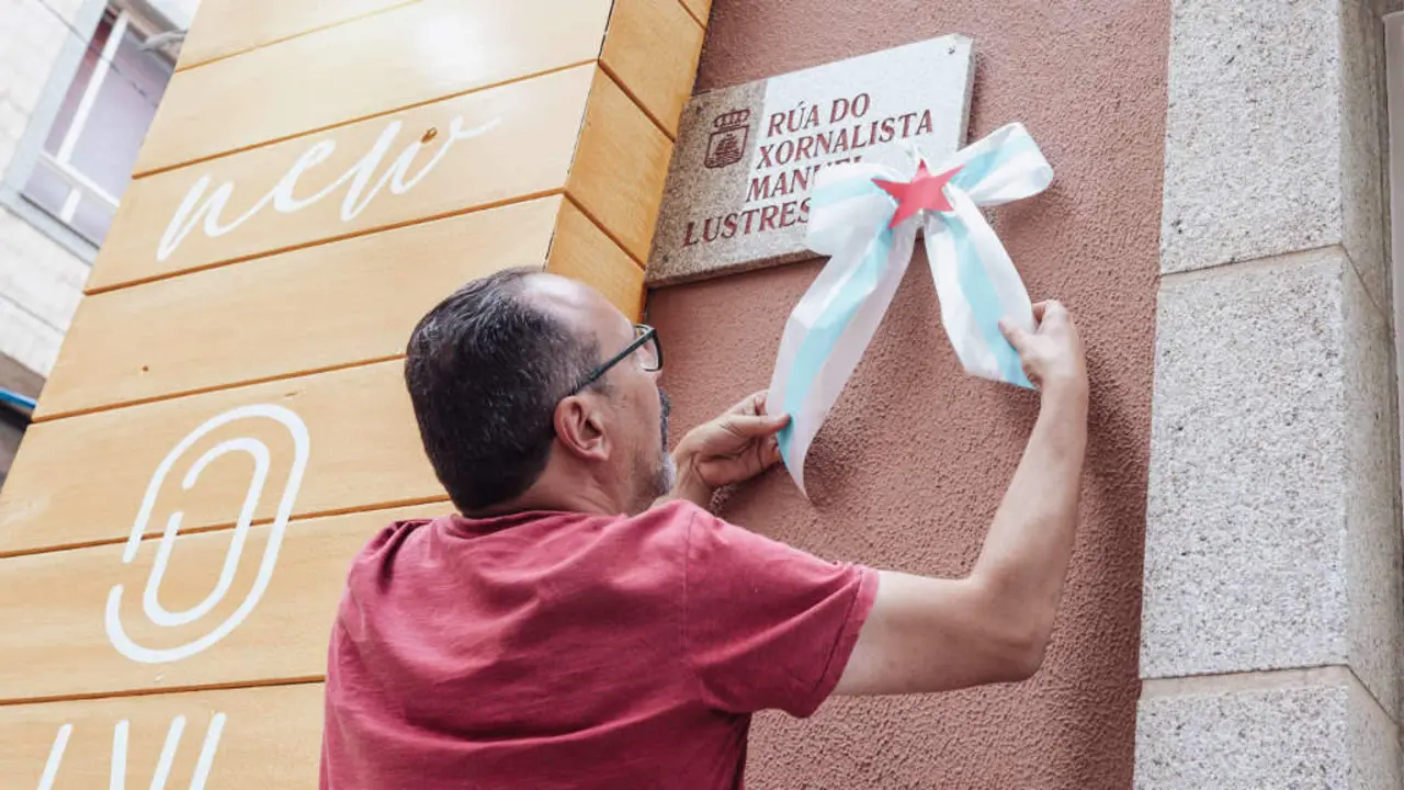 O respons&aacute;bel local do BNG de Ribeira, Rafael Pazos, colocando un lazo na placa da r&uacute;a do xornalista represaliado Manuel Lustres Rivas. (Foto: N&oacute;s Diario)