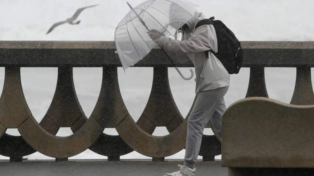 Unha persoa prot&eacute;xese da chuvia e do vento durante un temporal na Coru&ntilde;a (Foto: M. Dylan / Europa Press).