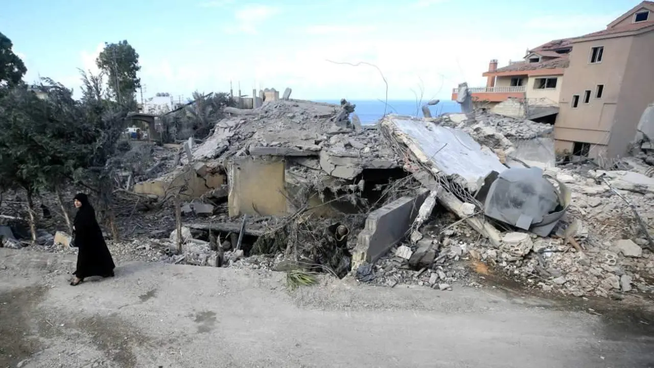 Unha muller cami&ntilde;a fronte a uns cascallos orixinados por un ataque do Ex&eacute;rcito de Israel en Naqura, no sur de L&iacute;bano. (Foto: Europa Press / Contacto / Ali Hashisho)