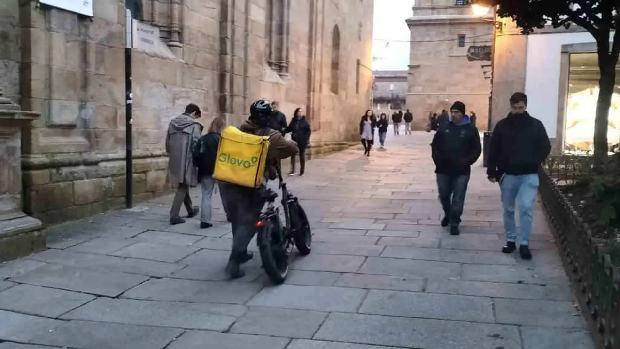 Un traballador de Glovo polas r&uacute;as da zona vella de Santiago de Compostela. (Foto: Riob&oacute; Prada)